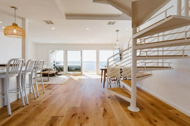 Beach style wooden spiral metal railing staircase photo in Other with metal risers