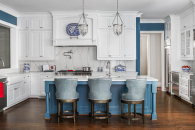 Example of a mid-sized transitional u-shaped dark wood floor and brown floor open concept kitchen design in Atlanta with a farmhouse sink, beaded inset cabinets, white cabinets, quartzite countertops, white backsplash, stone slab backsplash, stainless steel appliances, an island and white countertops