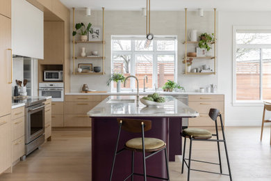 Example of a mid-sized trendy l-shaped light wood floor and brown floor eat-in kitchen design in San Francisco with an undermount sink, flat-panel cabinets, light wood cabinets, quartzite countertops, white backsplash, ceramic backsplash, paneled appliances, an island and beige countertops