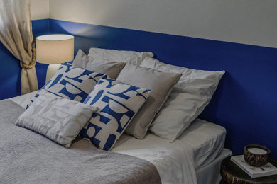 Réalisation d'une chambre parentale blanche et bois méditerranéenne de taille moyenne avec un mur bleu, parquet foncé, aucune cheminée, un sol marron et dressing.