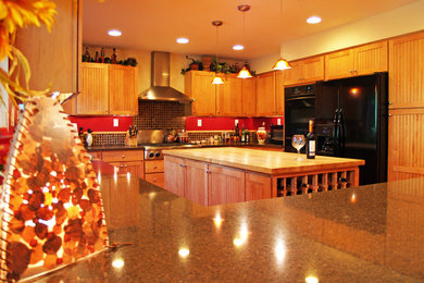 Example of a classic u-shaped eat-in kitchen design in Denver with an undermount sink, light wood cabinets, granite countertops, multicolored backsplash and black appliances