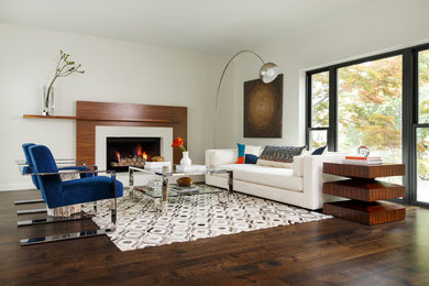 This is an example of a mid-sized contemporary formal open concept living room in Dallas with white walls, dark hardwood floors, a standard fireplace, a wood fireplace surround, no tv and brown floor.