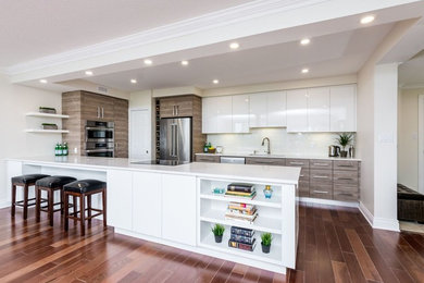 Large minimalist u-shaped kitchen photo in Other with flat-panel cabinets, quartz countertops, white backsplash, subway tile backsplash, stainless steel appliances and white countertops
