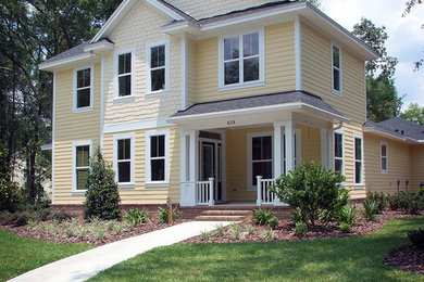 Large elegant yellow two-story wood exterior home photo in Jacksonville with a shingle roof