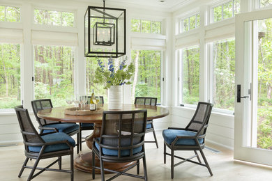 Inspiration for a beach style dining room in Boston with white walls, light hardwood floors, no fireplace and beige floor.