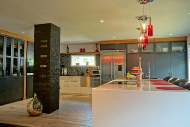 Inspiration for a contemporary ceramic tile eat-in kitchen remodel in Montreal with quartzite countertops, black backsplash, mosaic tile backsplash and stainless steel appliances