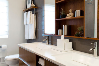 Mid-sized 1950s 3/4 gray tile and porcelain tile porcelain tile bathroom photo in Omaha with dark wood cabinets, a one-piece toilet, white walls, an integrated sink, concrete countertops and flat-panel cabinets