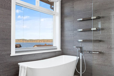 Inspiration for a large contemporary master bathroom in Seattle with flat-panel cabinets, black cabinets, a freestanding tub, a curbless shower, gray tile, porcelain tile, grey walls, porcelain floors, an undermount sink, engineered quartz benchtops, grey floor, an open shower and white benchtops.