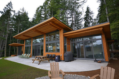 Photo of an expansive contemporary one-storey brown house exterior in Vancouver with wood siding and a flat roof.