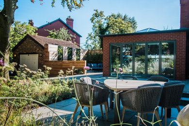 Design ideas for a large contemporary back partial sun garden for summer in Cheshire with a living wall and natural stone paving.