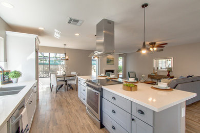 Inspiration for a mid-sized traditional open plan kitchen in Los Angeles with shaker cabinets, grey cabinets, quartzite benchtops, stainless steel appliances, medium hardwood floors, with island and beige floor.