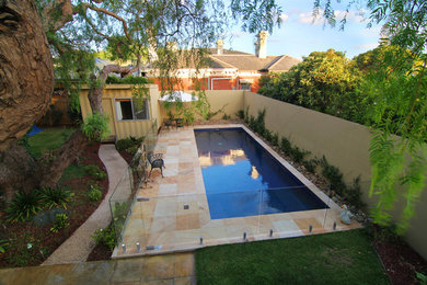 Design ideas for a mid-sized traditional backyard rectangular pool in Melbourne with natural stone pavers.