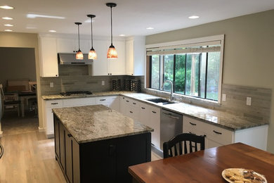 Eat-in kitchen - mid-sized contemporary l-shaped light wood floor eat-in kitchen idea in Seattle with a double-bowl sink, recessed-panel cabinets, white cabinets, granite countertops, gray backsplash, stone tile backsplash, stainless steel appliances and an island