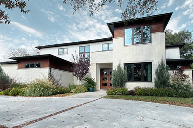 Example of a large trendy two-story brick exterior home design in Dallas