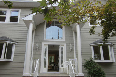 Large traditional gray three-story wood house exterior idea in New York with a hip roof and a shingle roof