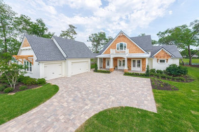 Example of a classic white two-story stucco gable roof design in Jacksonville