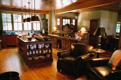 Example of a large classic u-shaped medium tone wood floor and brown floor enclosed kitchen design in Atlanta with flat-panel cabinets, dark wood cabinets, an island and an undermount sink