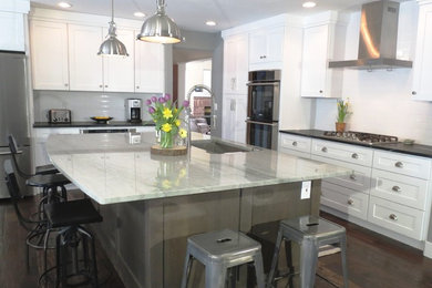 Inspiration for a mid-sized timeless l-shaped dark wood floor open concept kitchen remodel in Denver with an undermount sink, shaker cabinets, medium tone wood cabinets, granite countertops, white backsplash, ceramic backsplash, stainless steel appliances and an island