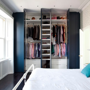 Idée de décoration pour une chambre parentale design de taille moyenne avec un mur vert, un sol en bois foncé et un manteau de cheminée en bois.