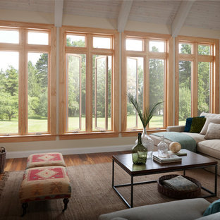 Imagen de salón abierto, mediterráneo, grande, con paredes beige, suelo de madera en tonos medios y marco de chimenea de madera