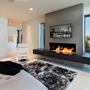 Großes Modernes Hauptschlafzimmer mit beiger Wandfarbe, Porzellan-Bodenfliesen, Gaskamin und Kaminumrandung aus Beton in Phoenix