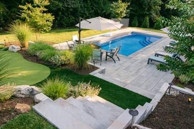 Large transitional backyard concrete paver and rectangular pool landscaping photo in Richmond