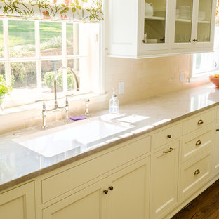 Mittelgroße Klassische Küche in U-Form mit Vorratsschrank, Doppelwaschbecken, Schrankfronten im Shaker-Stil, weißen Schränken, Mineralwerkstoff-Arbeitsplatte, Küchenrückwand in Beige, Rückwand aus Porzellanfliesen, weißen Elektrogeräten und dunklem Holzboden in Portland