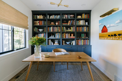Ejemplo de despacho tradicional renovado de tamaño medio con paredes blancas, suelo de madera clara y escritorio independiente
