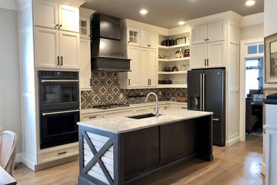 Example of a mid-sized cottage l-shaped light wood floor and brown floor eat-in kitchen design in Other with a single-bowl sink, flat-panel cabinets, white cabinets, quartz countertops, multicolored backsplash, cement tile backsplash, colored appliances, an island and white countertops