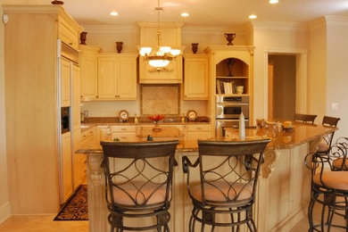 Mid-sized elegant l-shaped ceramic tile eat-in kitchen photo in Other with a farmhouse sink, raised-panel cabinets, beige cabinets, granite countertops, beige backsplash, ceramic backsplash, black appliances and an island