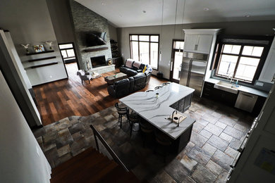 Open concept kitchen - large eclectic l-shaped porcelain tile and multicolored floor open concept kitchen idea in Other with a farmhouse sink, shaker cabinets, quartz countertops, white backsplash, glass tile backsplash, stainless steel appliances, an island and white countertops