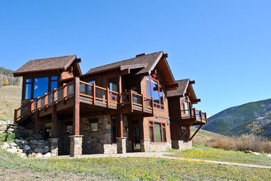 This is an example of a large country two-storey brown house exterior in Denver with mixed siding, a gable roof and a shingle roof.