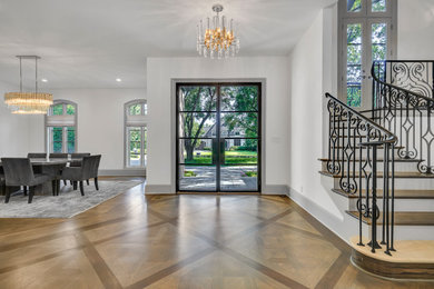 Design ideas for a transitional foyer in Dallas with white walls, light hardwood floors, a double front door, a black front door and brown floor.