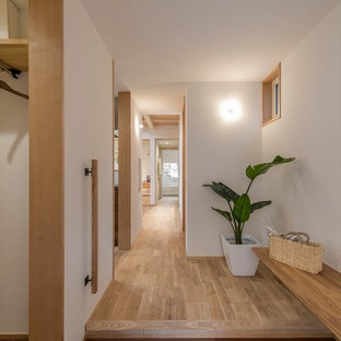 横浜のモダンスタイルのおしゃれな玄関 (白い壁、濃色無垢フローリング、茶色い床) の写真