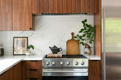 Example of a mid-century modern galley ceramic tile and gray floor eat-in kitchen design in Other with a drop-in sink, flat-panel cabinets, dark wood cabinets, marble countertops, white backsplash, marble backsplash, stainless steel appliances, an island and white countertops