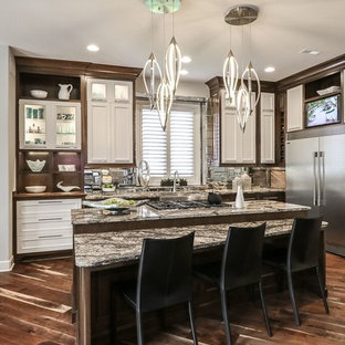 Mid-sized contemporary kitchen pantry pictures - Inspiration for a mid-sized contemporary l-shaped medium tone wood floor kitchen pantry remodel in Kansas City with a double-bowl sink, recessed-panel cabinets, white cabinets, granite countertops, gray backsplash, ceramic backsplash, stainless steel appliances and an island