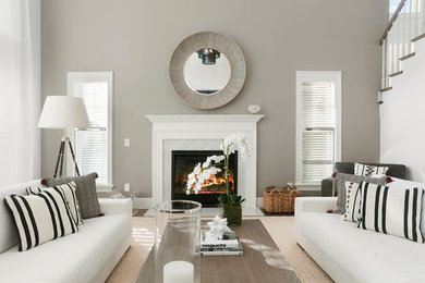 Beach style formal enclosed living room in New York with grey walls, dark hardwood floors, a standard fireplace, a stone fireplace surround and brown floor.
