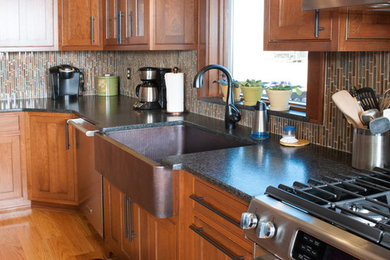 Mid-sized transitional l-shaped medium tone wood floor eat-in kitchen photo in Orange County with a farmhouse sink, shaker cabinets, medium tone wood cabinets, granite countertops, multicolored backsplash, matchstick tile backsplash, stainless steel appliances and an island