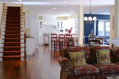Example of a mid-sized classic l-shaped medium tone wood floor eat-in kitchen design in Minneapolis with a farmhouse sink, beaded inset cabinets, white cabinets, granite countertops, white backsplash, ceramic backsplash, stainless steel appliances and an island