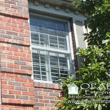 White Andersen 400 Tilt Wash Windows with mixed red toned brick & tan shutters.