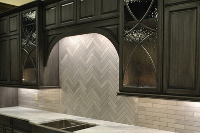 Eat-in kitchen - transitional eat-in kitchen idea in Columbus with an undermount sink, raised-panel cabinets, gray cabinets, granite countertops, gray backsplash, stone tile backsplash and stainless steel appliances