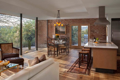Inspiration for a large contemporary medium tone wood floor great room remodel in Phoenix with red walls, a standard fireplace and a brick fireplace