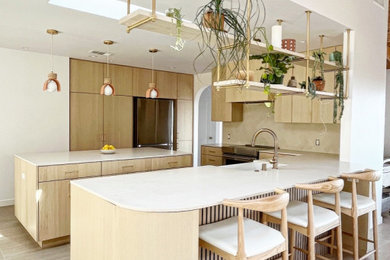 Example of a mid-sized trendy u-shaped porcelain tile and beige floor eat-in kitchen design in Los Angeles with an undermount sink, flat-panel cabinets, light wood cabinets, quartz countertops, beige backsplash, cement tile backsplash, stainless steel appliances, an island and white countertops