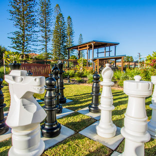 Design ideas for a mid-sized contemporary backyard formal garden in Brisbane with with outdoor playset and concrete pavers.