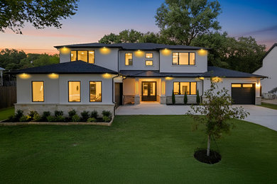 Inspiration for a large transitional white two-story stucco house exterior remodel in Dallas with a hip roof, a metal roof and a black roof