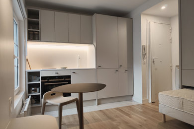Aménagement d'une petite cuisine ouverte linéaire, encastrable et grise et blanche moderne avec un évier encastré, un placard à porte affleurante, des portes de placard grises, un plan de travail en quartz, une crédence blanche, une crédence en quartz modifié, un sol en carrelage de céramique, un sol blanc, un plan de travail blanc et machine à laver.
