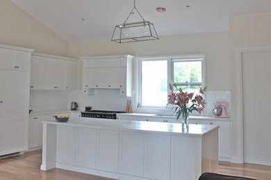 Design ideas for a mid-sized traditional l-shaped kitchen in Sydney with white splashback and with island.