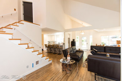 Example of a mid-sized mid-century modern enclosed painted wood floor living room design in San Diego with white walls, a hanging fireplace and a wall-mounted tv
