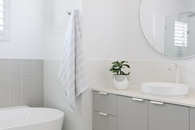 Modern kids bathroom in Perth with grey cabinets, a freestanding tub, white tile, porcelain floors, a vessel sink, engineered quartz benchtops, a hinged shower door, white benchtops, a single vanity and a built-in vanity.