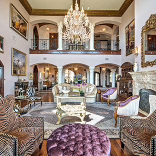 Imagen de salón para visitas abierto, mediterráneo, extra grande, sin televisor, con suelo de madera oscura, paredes púrpuras, chimenea tradicional, marco de chimenea de piedra y suelo marrón